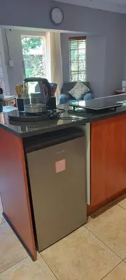 a kitchen with a counter top with a dishwasher at Lily's Inn in Centurion
