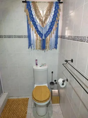 a bathroom with a toilet with a wooden seat at Lily's Inn in Centurion