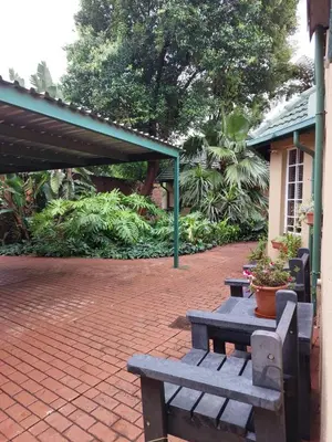 a picnic table and bench on a brick patio at Lily's Inn in Centurion