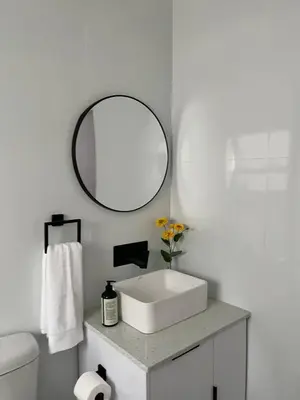 a white bathroom with a sink and a mirror at Condo in Sunninghill, Sandton in Sandton