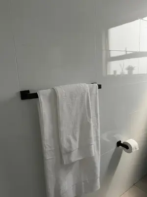 a white towel hanging on a towel rack in a bathroom at Condo in Sunninghill, Sandton in Sandton