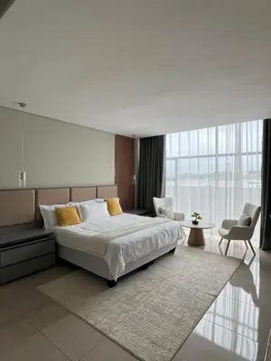 a bedroom with a large bed and a large window at The Legacy Hotel and Spa in Tzaneen