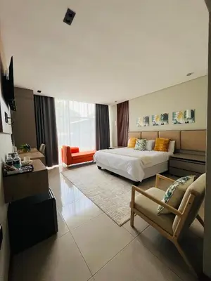 a large bedroom with a bed and a couch at The Legacy Hotel and Spa in Tzaneen
