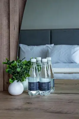 four bottles of water on a table next to a bed at The Legacy Hotel and Spa in Tzaneen