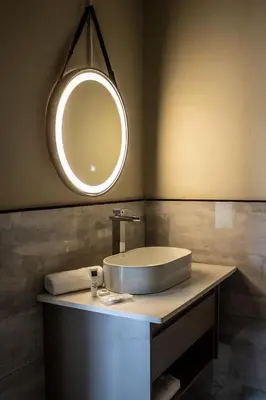 a bathroom with a sink and a mirror at The Legacy Hotel and Spa in Tzaneen