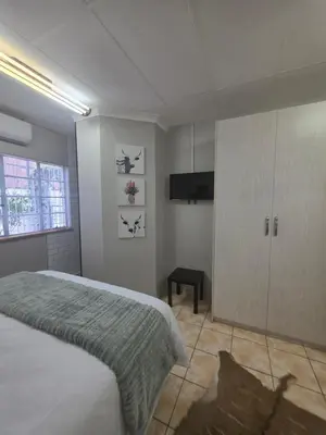 a bedroom with a bed and a cabinet and a television at 153 A Marshall in Polokwane