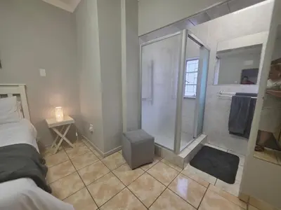 a bathroom with a shower and a bed in a room at 153 A Marshall in Polokwane