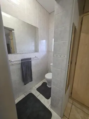a bathroom with a toilet and a mirror at 153 A Marshall in Polokwane