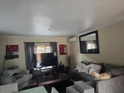 a living room with a couch and a tv at Garys Place -Work-ready, family-friendly, and braai-happy in Centurion