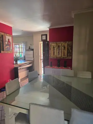 a kitchen with a glass table and white chairs at Garys Place -Work-ready, family-friendly, and braai-happy in Centurion