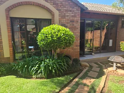 a brick house with a tree in the front yard at Garys Place -Work-ready, family-friendly, and braai-happy in Centurion