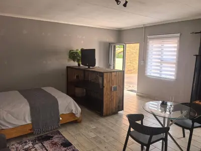 a bedroom with a bed and a table with a tv at Infinity Piece at Centurion in Centurion