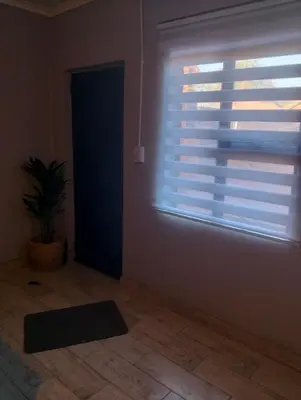 a room with a window with a plant and a rug at Infinity Piece at Centurion in Centurion