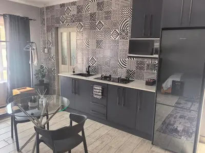 a kitchen with a glass table and a kitchen with a dining room at Infinity Piece at Centurion in Centurion