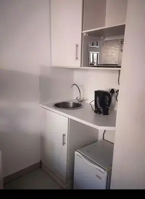 a small kitchen with a sink and a microwave at Soteria House in Kempton Park