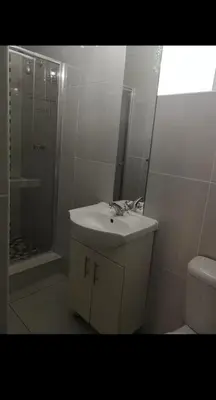 a bathroom with a sink and a shower and a toilet at Soteria House in Kempton Park