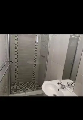 a bathroom with a shower and a white sink at Soteria House in Kempton Park