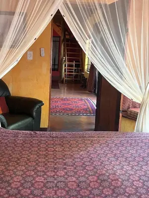 a bedroom with a bed with curtains and a couch at Reverie Safari Lodge, Marloth Park in Marloth Park