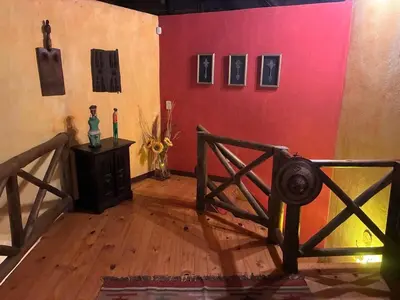 a room with a red wall and a wooden floor at Reverie Safari Lodge, Marloth Park in Marloth Park