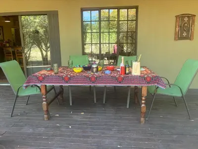 a table with a table cloth on it with chairs at Reverie Safari Lodge, Marloth Park in Marloth Park