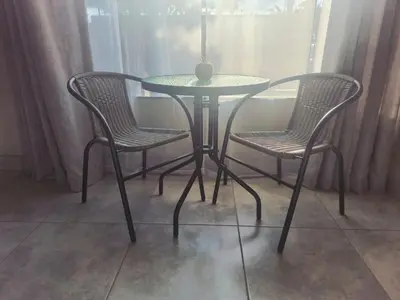 a table with two chairs and a table with a vase on it at Roots of Grace in Polokwane