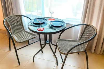 a table with two chairs and two glasses on it at Roots of Grace in Polokwane