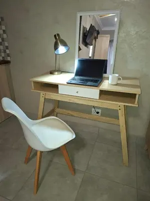 a desk with a laptop and a chair and a mirror at Roots of Grace in Polokwane