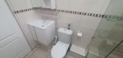 a white bathroom with a toilet and a sink at 329 on 30th Avenue Villieria Drian in Pretoria