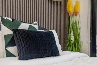 a bed with a pillow and a vase of flowers at 2 Bed 2 Bath Apartment, Ellipse, Waterfall in Midrand