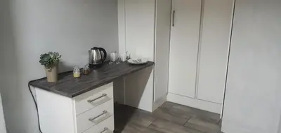 a kitchen with white cabinets and a wooden counter top at 329 on 30th Avenue Villieria Justin in Pretoria