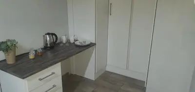 a kitchen with white cabinets and a wooden counter top at 329 on 30th Avenue Villieria Justin in Pretoria