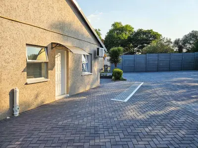 a house with a brick driveway next to a building at The M GuestHouse in Kempton Park