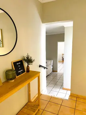 a living room with a table and a mirror at Springbok 47 in Polokwane