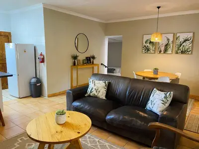 a living room with a leather couch and a table at Springbok 47 in Polokwane