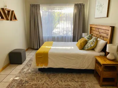 a bedroom with a large bed and a window at Springbok 47 in Polokwane