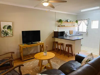 a living room with a couch and a kitchen at Springbok 47 in Polokwane