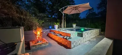 a patio with a fire pit and an umbrella at Marloth Birdhaven in Marloth Park
