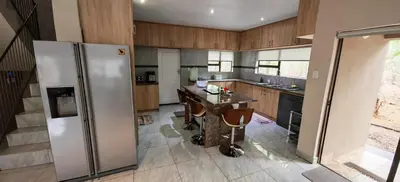 a kitchen with a stainless steel refrigerator and a table at Marloth Birdhaven in Marloth Park