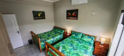 a bedroom with a bed and two pictures on the wall at Marloth Birdhaven in Marloth Park