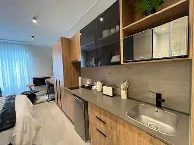 a kitchen with a sink and a bed in a room at The Hideaway at Menlyn Maine Trilogy in Pretoria