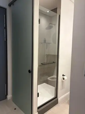 a glass shower door in a bathroom with a toilet at The Hideaway at Menlyn Maine Trilogy in Pretoria