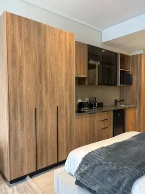 a bedroom with wooden cabinets and a bed at The Hideaway at Menlyn Maine Trilogy in Pretoria