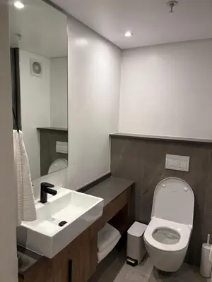 a bathroom with a white toilet and a sink at The Hideaway at Menlyn Maine Trilogy in Pretoria