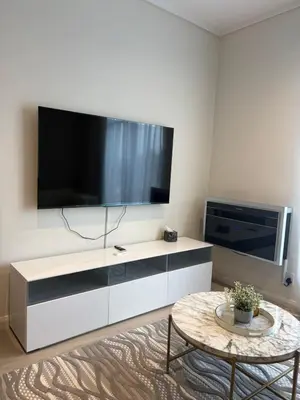 a living room with a large television and a table at The Hideaway at Menlyn Maine Trilogy in Pretoria