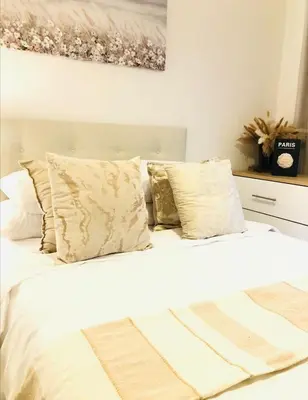 a bedroom with a bed with white sheets and pillows at Apartment at the Blyde in Pretoria