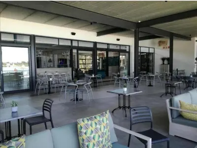 a restaurant with tables and chairs and windows at Apartment at the Blyde in Pretoria