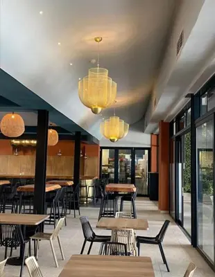 a restaurant with tables and chairs and chandeliers at Apartment at the Blyde in Pretoria