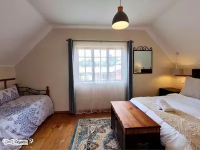 a bedroom with two beds and a window at Amber & Birch in Dullstroom