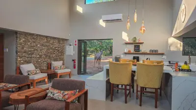 a kitchen and living room with a table and chairs at 2219 Kruger Wild in Marloth Park