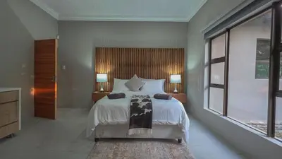a bedroom with a large bed and two lamps at 2219 Kruger Wild in Marloth Park